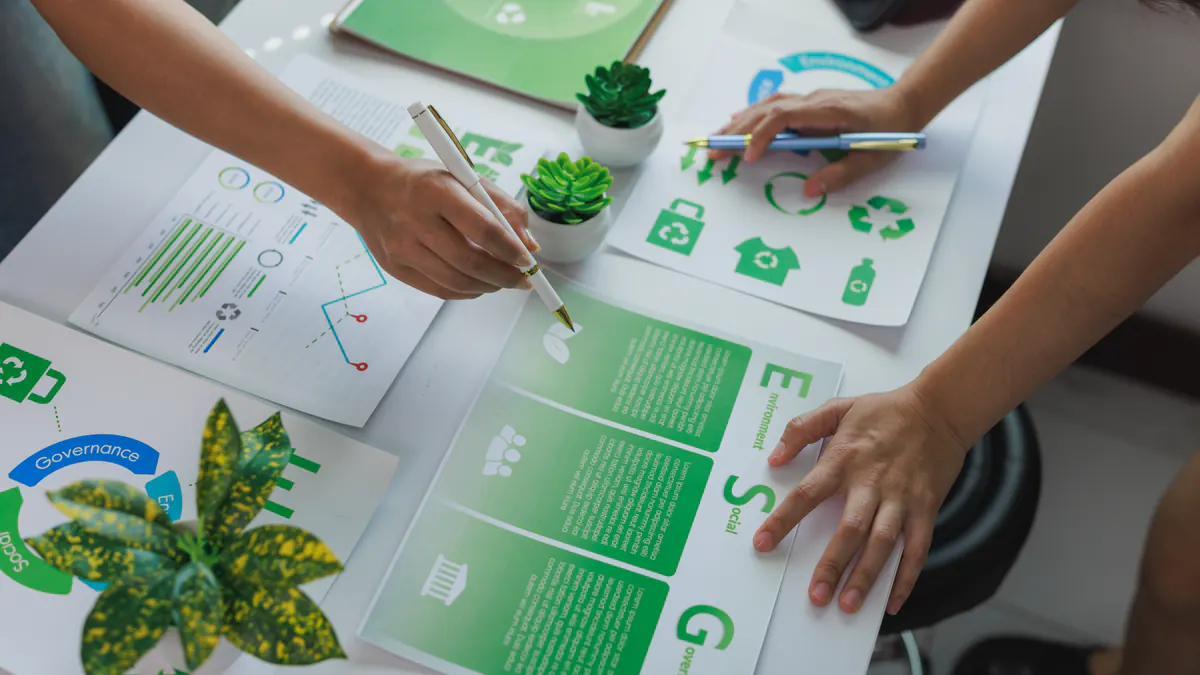 Overhead view of ESG reports and sustainability charts under review on a desk