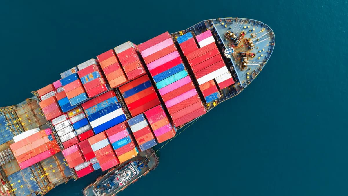 Aerial top view of a container ship loaded with cargo, sailing on open sea